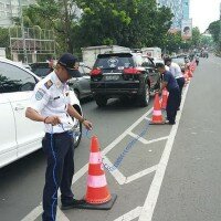 Petugas sedang melakukan pemesangan pembatas jalan di JLNT Casablangka. (wandi)